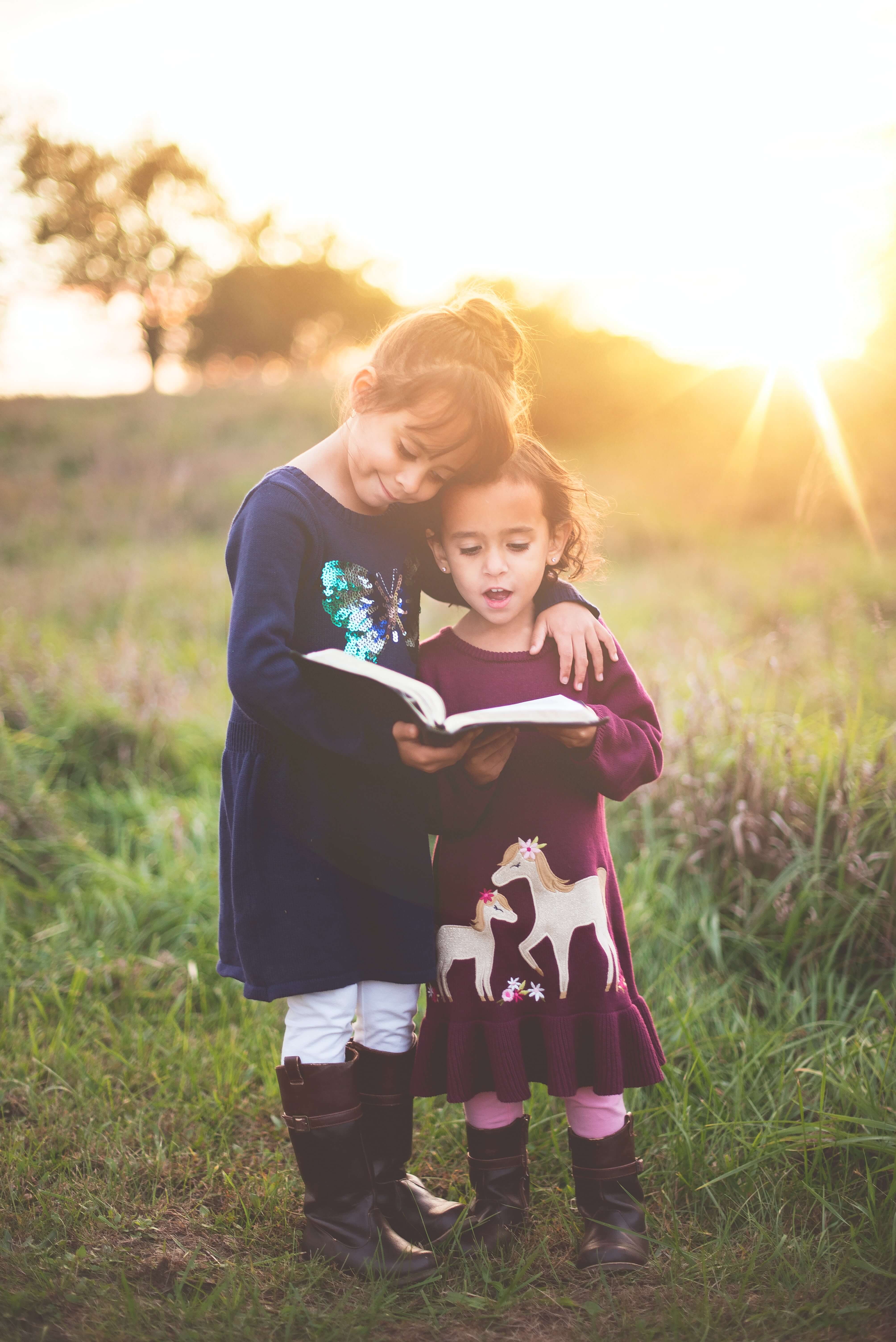 Children reading a book at golden hour