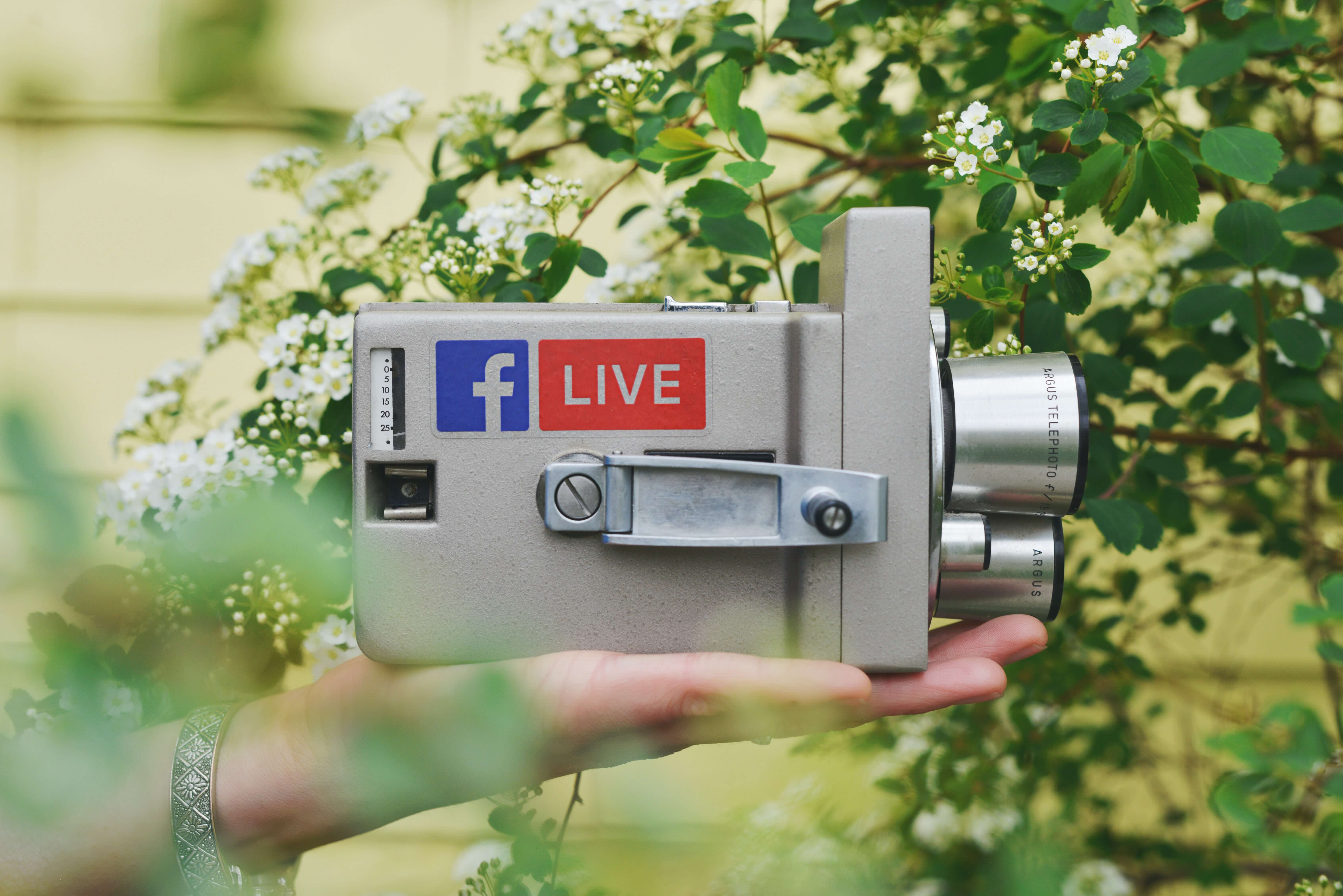 Person holding a camera with Facebook logo on it